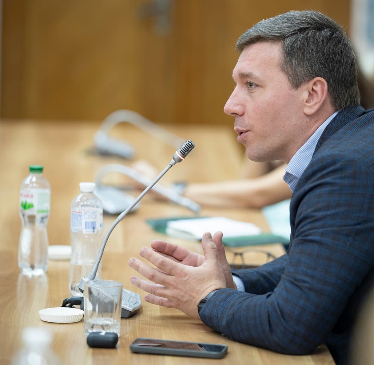 Експертний виступ на діловій зустрічі з питань розвитку людського капіталу та стійкості бізнесу Спікер виступає на діловій зустрічі за конференційним столом, обговорюючи розвиток людського капіталу, управління персоналом, корпоративну стійкість, HR-стратегії та підвищення ефективності бізнесу