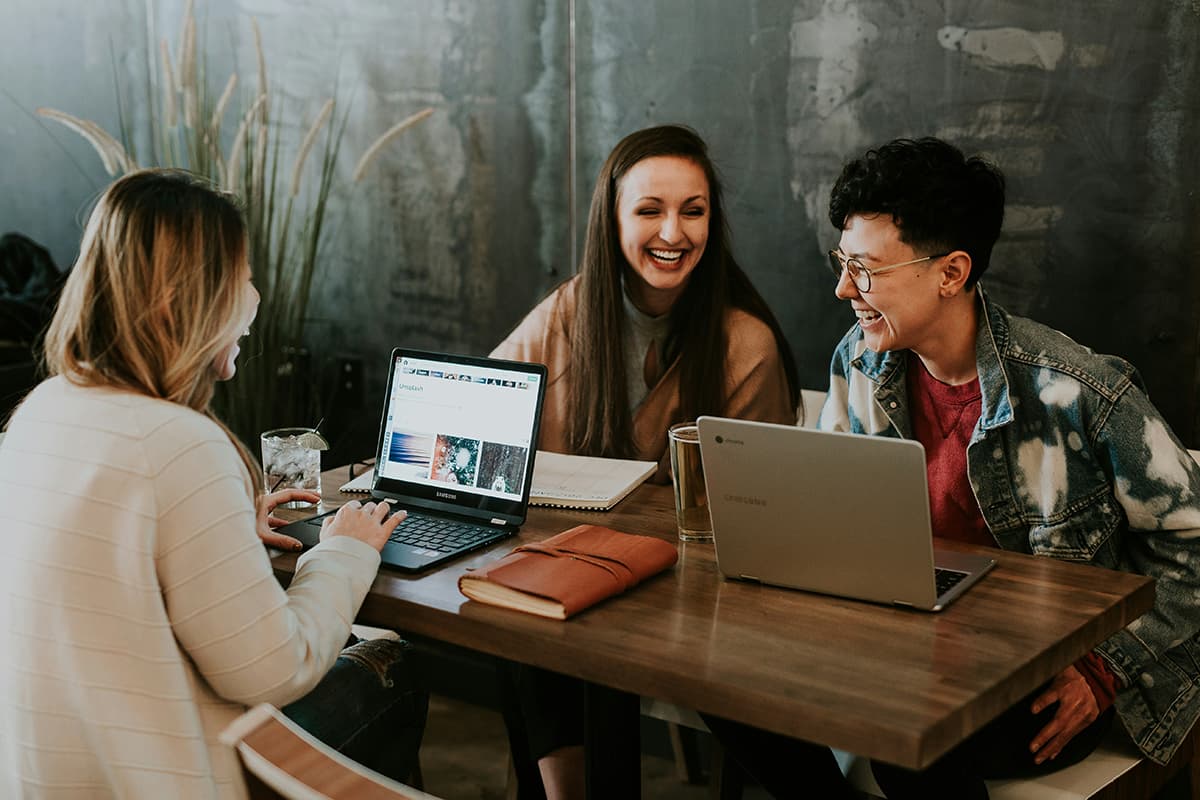 Team members working together with laptops during a meeting, symbolizing employee training and the development of ESG competencies within a company
